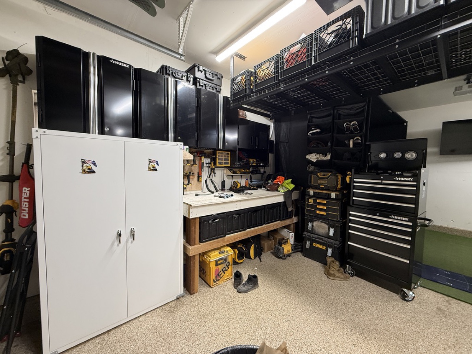 Finished tool wall — Husky modular cabinets, custom workbench, pegboard, DeWalt tool stack, Husky rolling chest, overhead wire-rack storage. Truckee garage, November 2024.