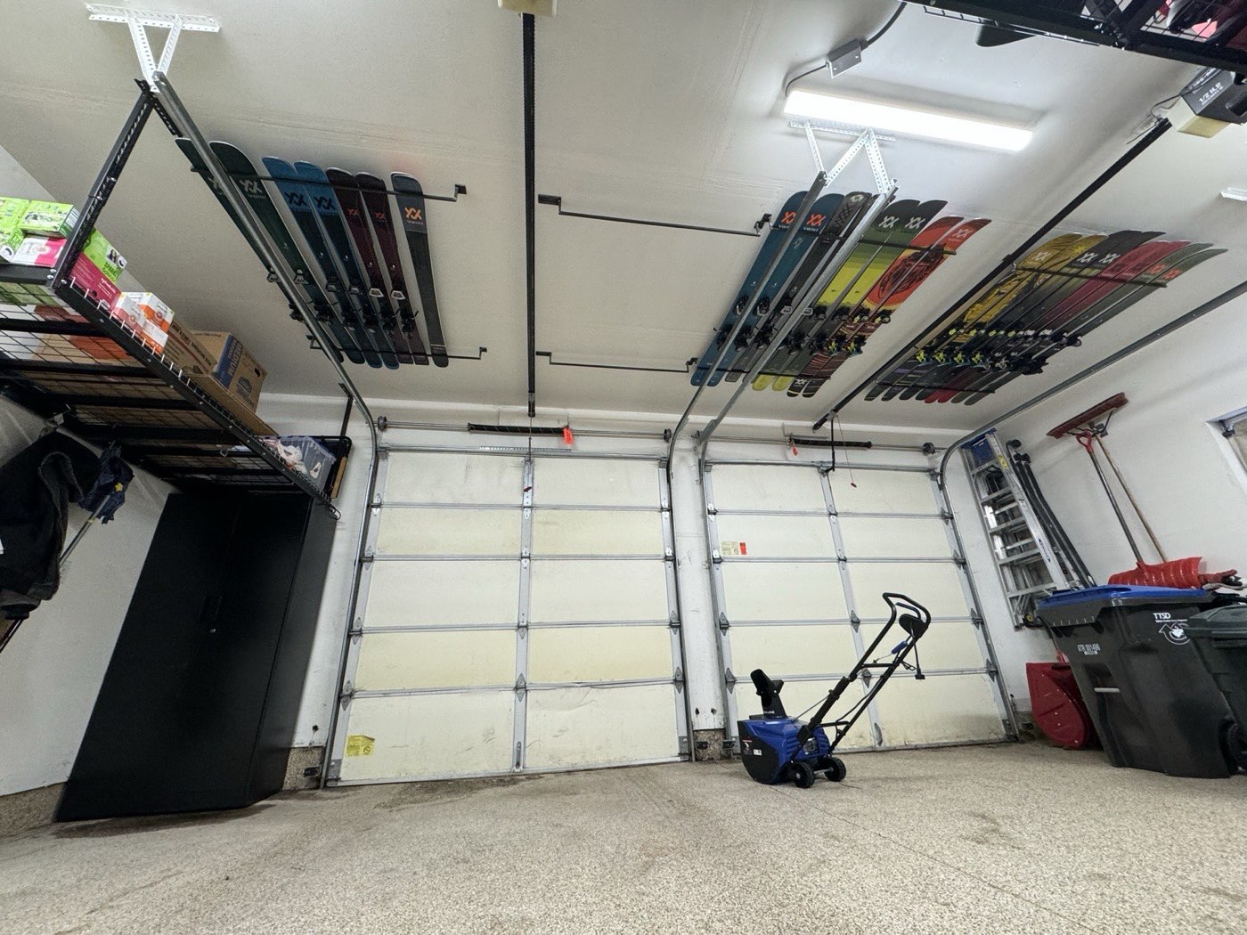 Full garage view with ski storage system and both doors up