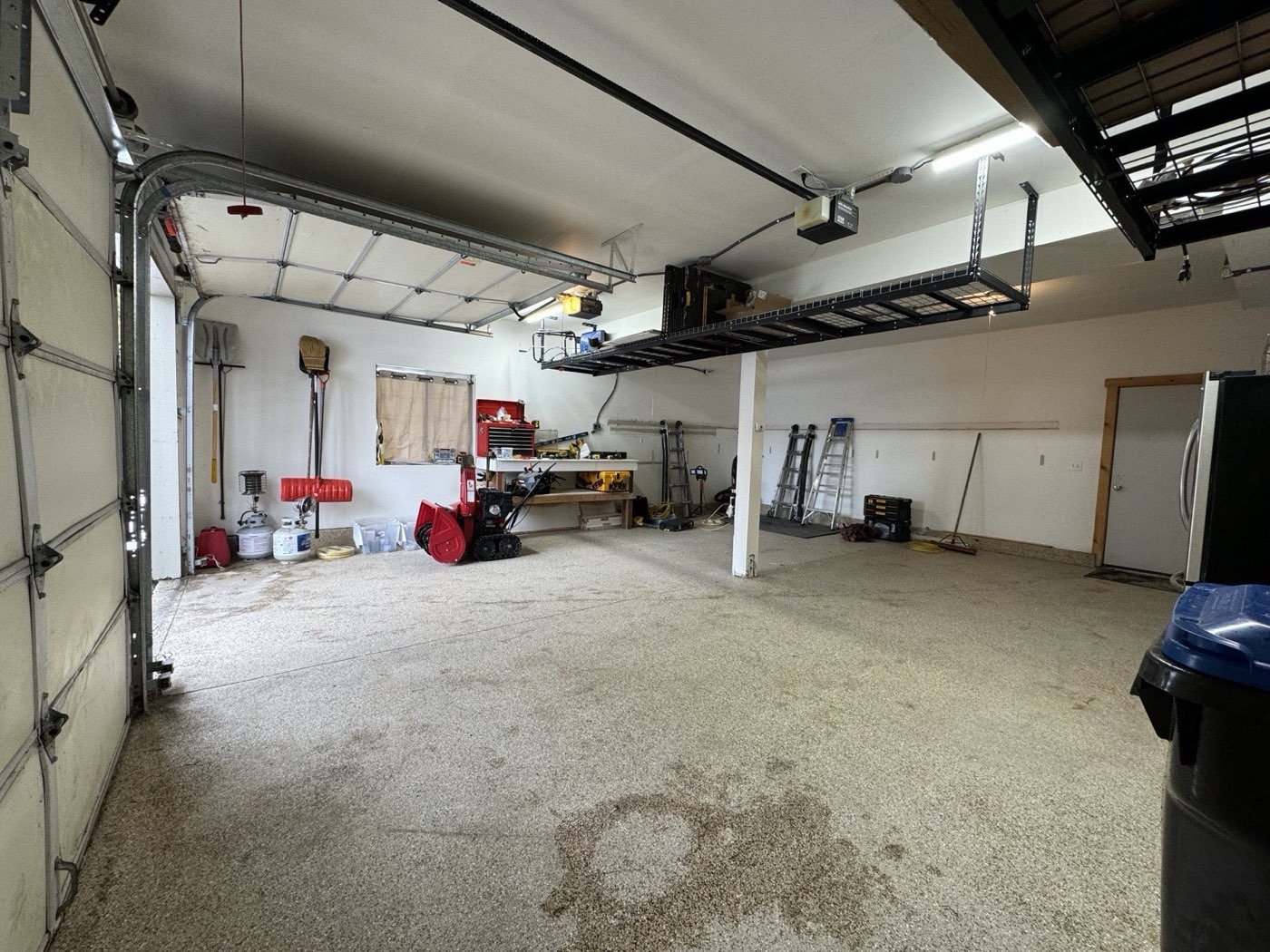 Garage with doors up showing completed ski storage and snowblower clearance